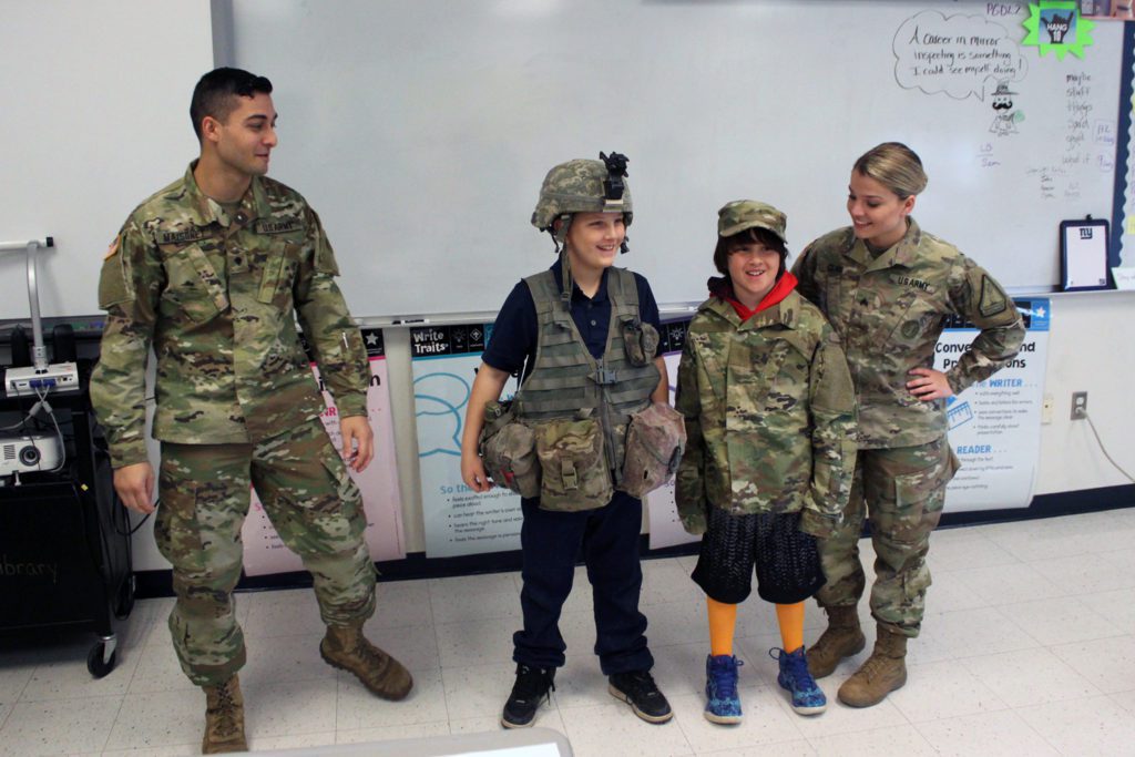 students try on army gear with National Guard Soldiers