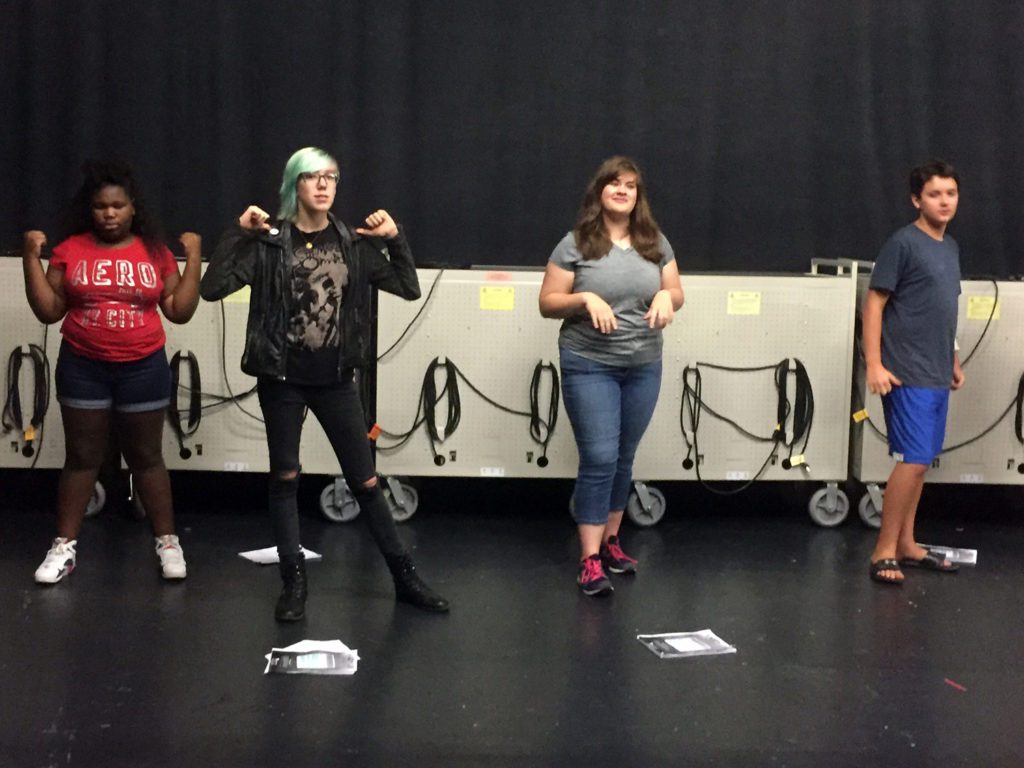 four student rehearsing for summer music camp's musical