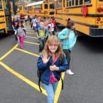 girl waves after getting off the bus