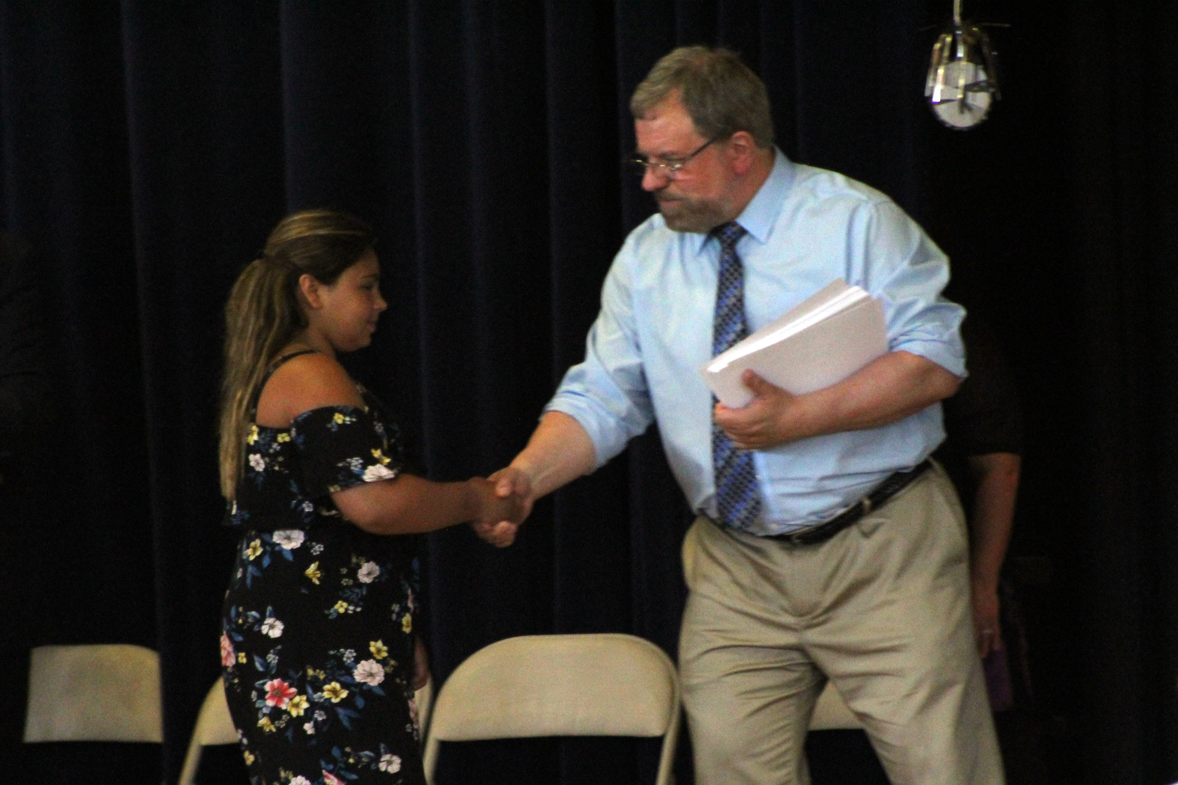 student shakes hands with teacher