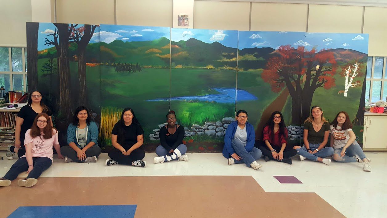 students pose with completed mural showing Catskill Mountains landscape