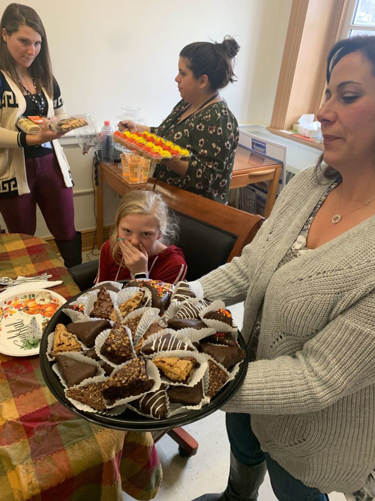 teachers hold up trays of desserts