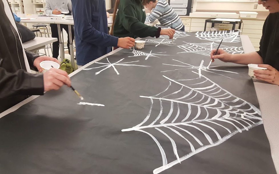 students working on mural showing of spiderwebs