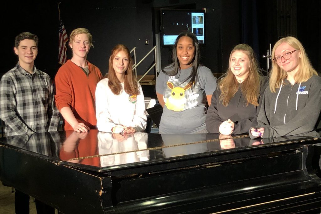 Matthew Caro, Elisha Clause, Isabella Truncale, Ava Higgins, Grace McCulloch, and Deandra Catterson. standing at piano