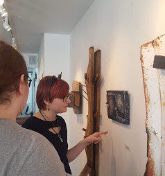 teenagers looking at artwork made from found scrapwood