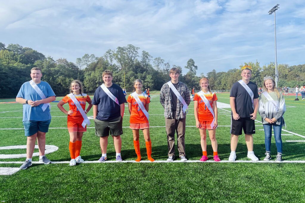 three young couples standing on football field