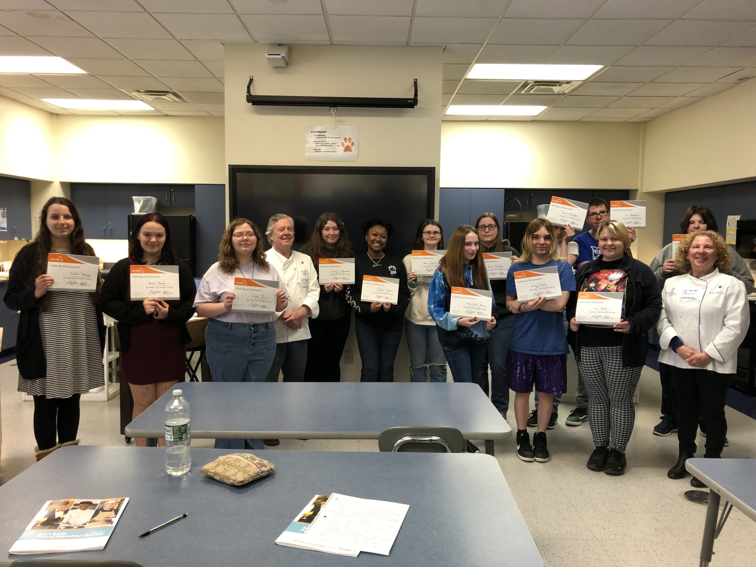 students pose with certificates
