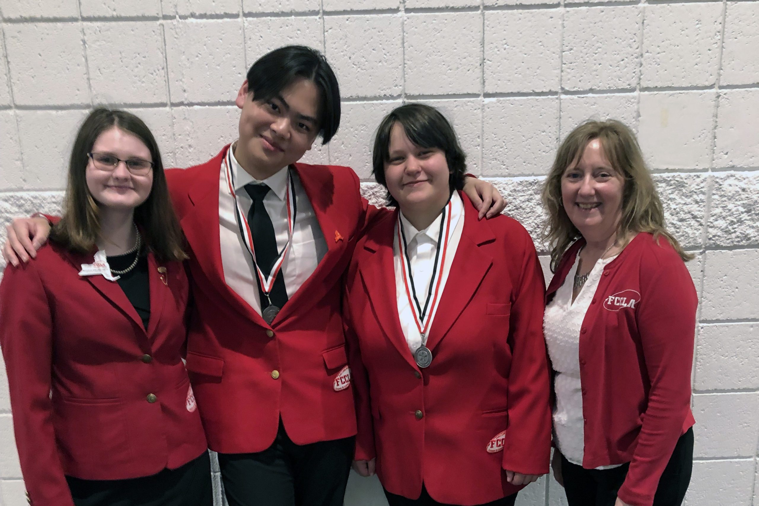 three students and woman wearing red FCCLA blazers