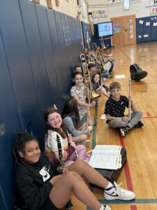 elementary students with instruments sitting on gym floor