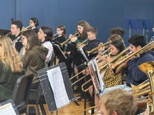 elementary and high school students playing brass instruments.