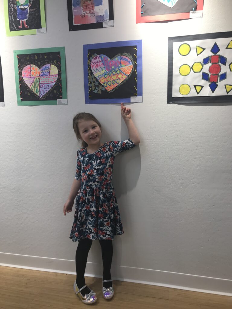 girl pointing to painting on wall