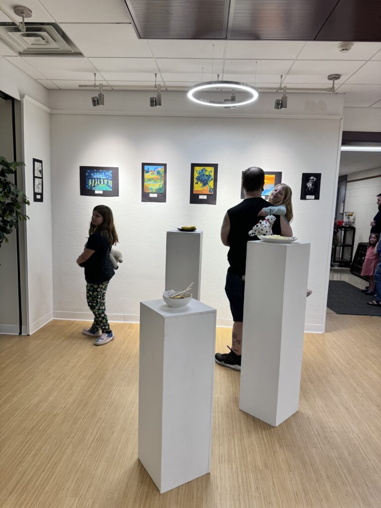 people looking at art on gallery wall