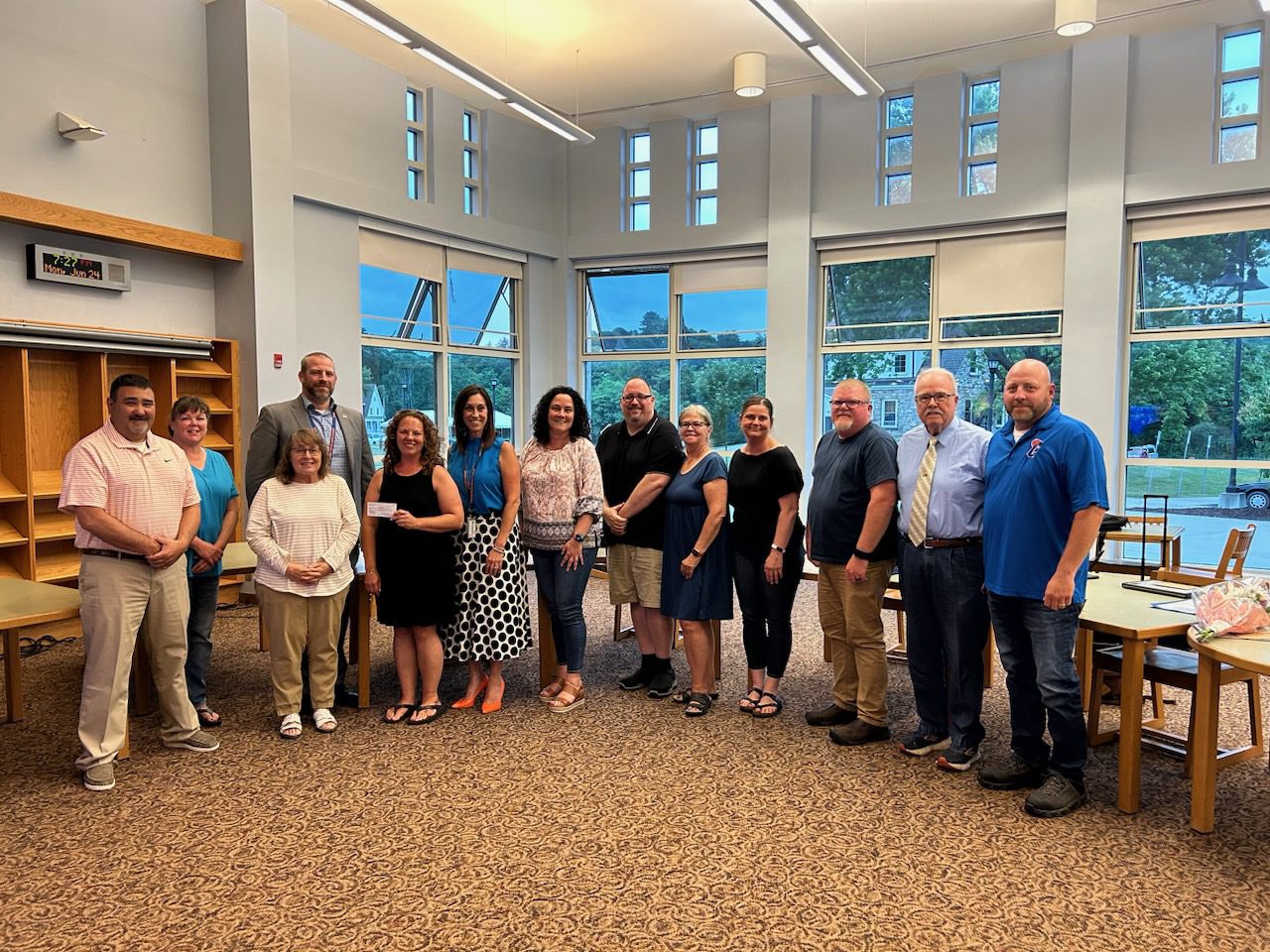Catskill administrators, Board members and Teacher Association members pose with check in Catskill High School library. 