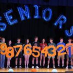 top ten seniors holding respective numbers on CHS stage