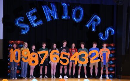 top ten seniors holding respective numbers on CHS stage
