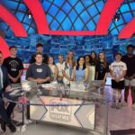 students pose for photo with on-air talent in Fox Weather studio.