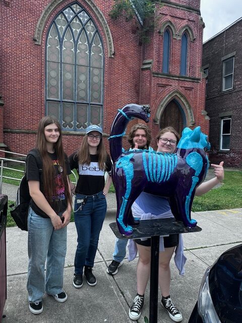 students pose with cat statue