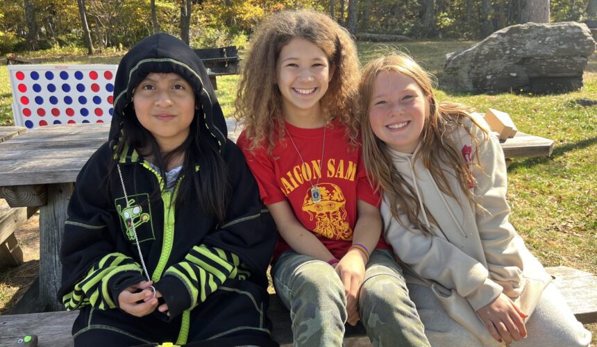 students sitting on bench smiling
