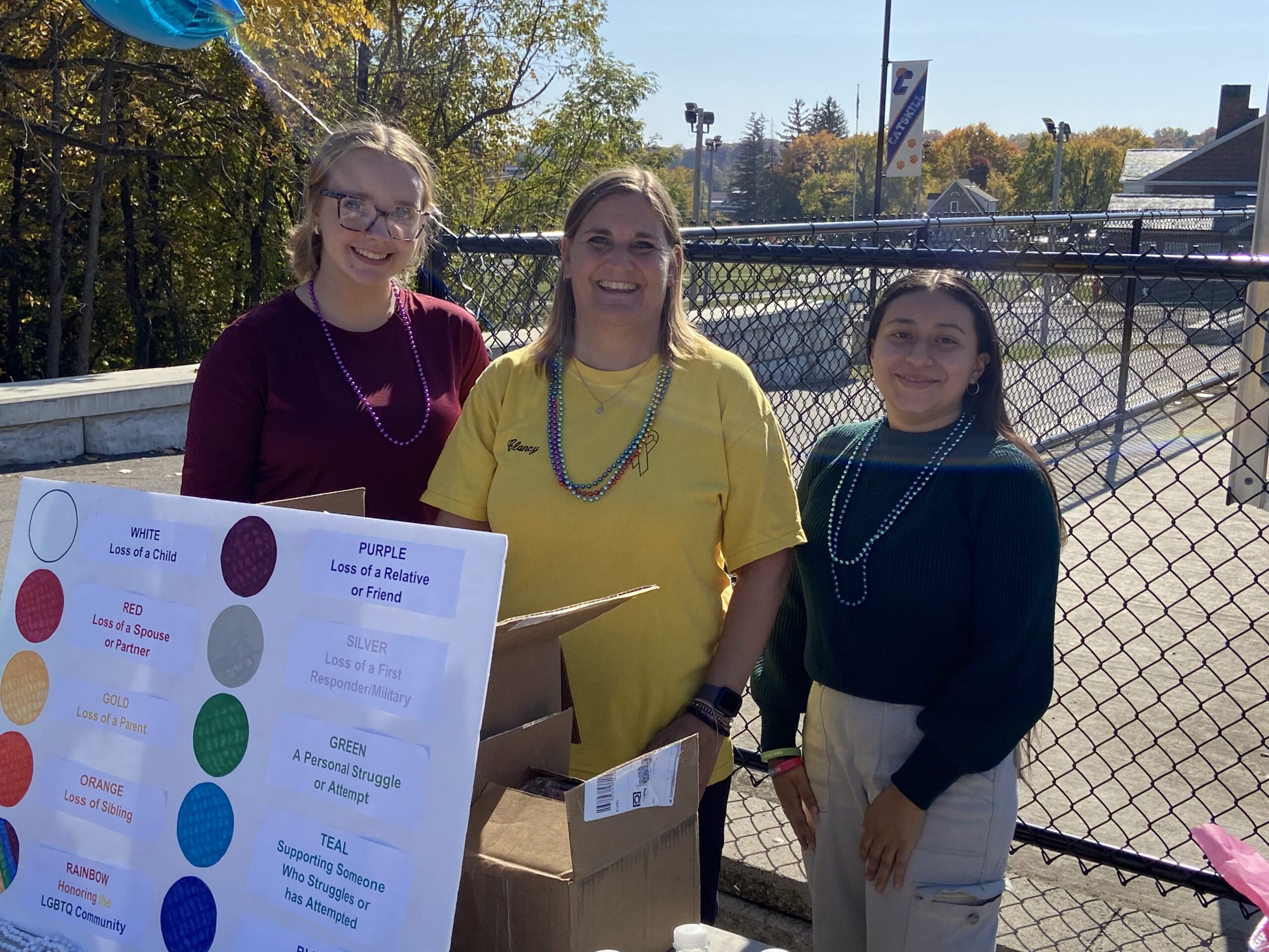 students and teacher posing for photo at information booth
