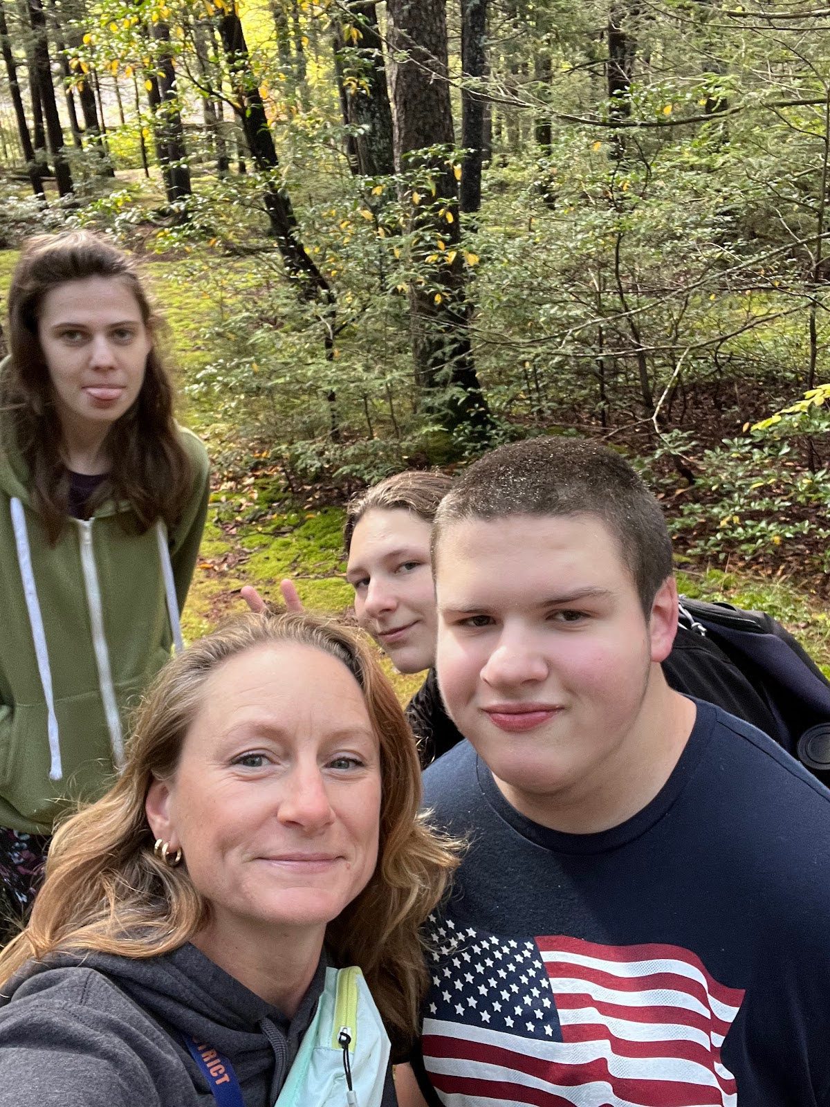 students and staff in wooded area
