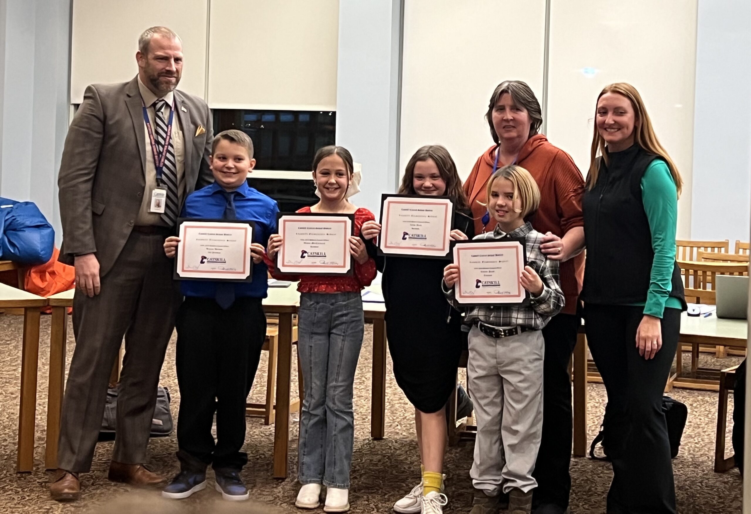 Student council officers pose with certificates, superintendent, and advisors