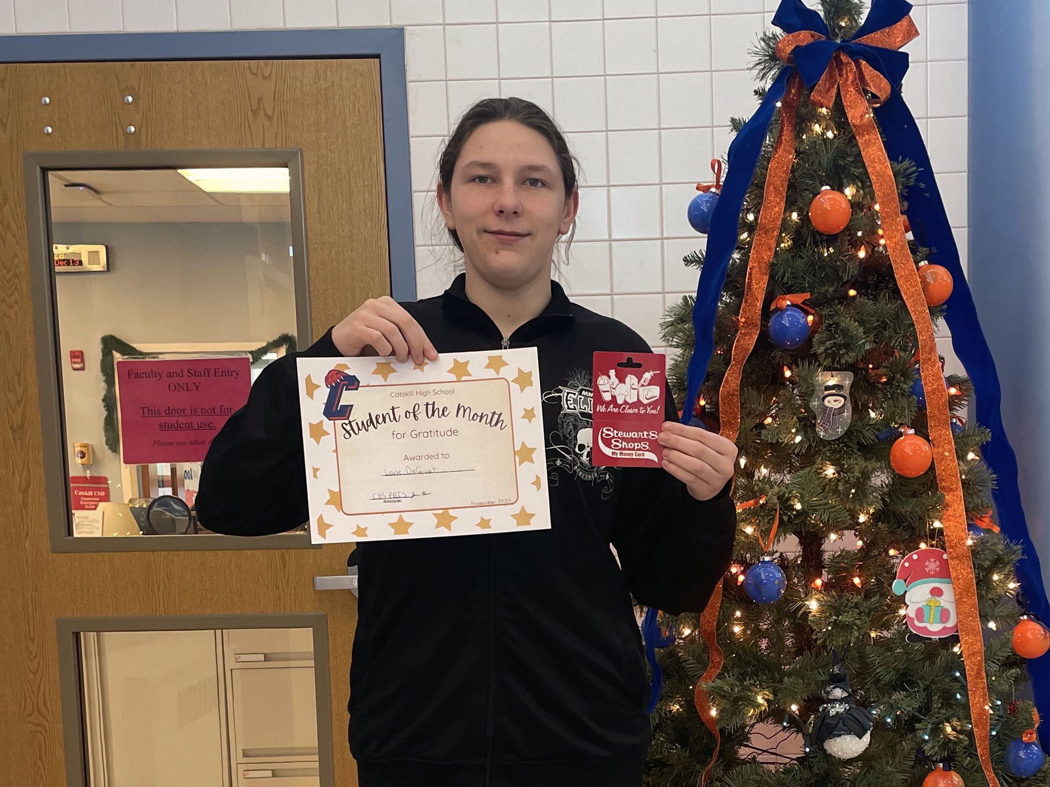 teenage student holding certificate and smiling
