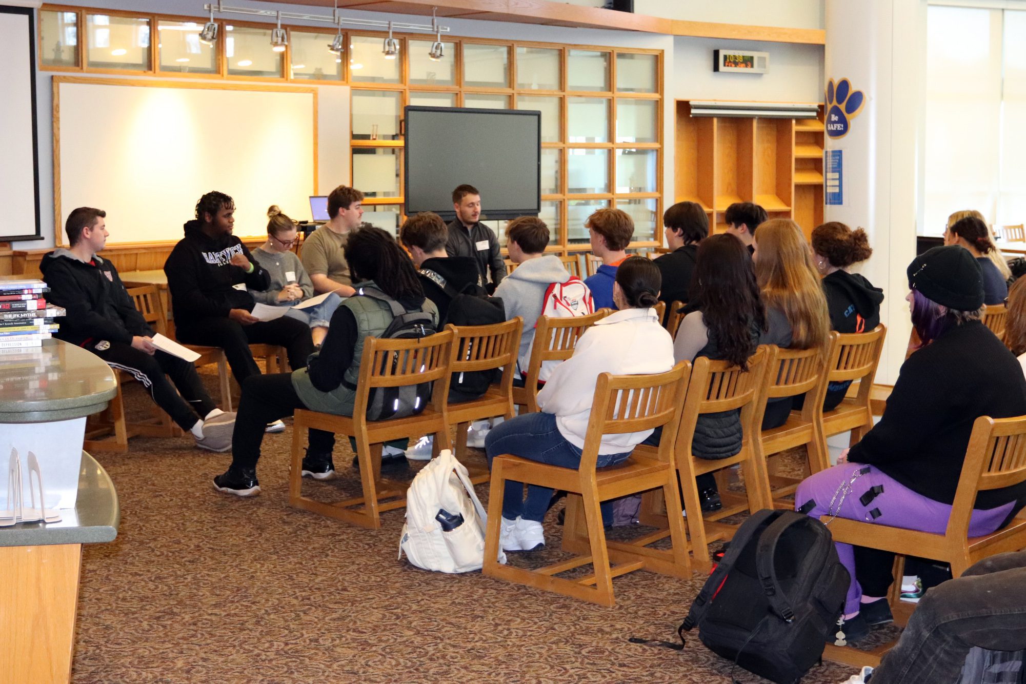 panel of college students seated before audience of high school seniors