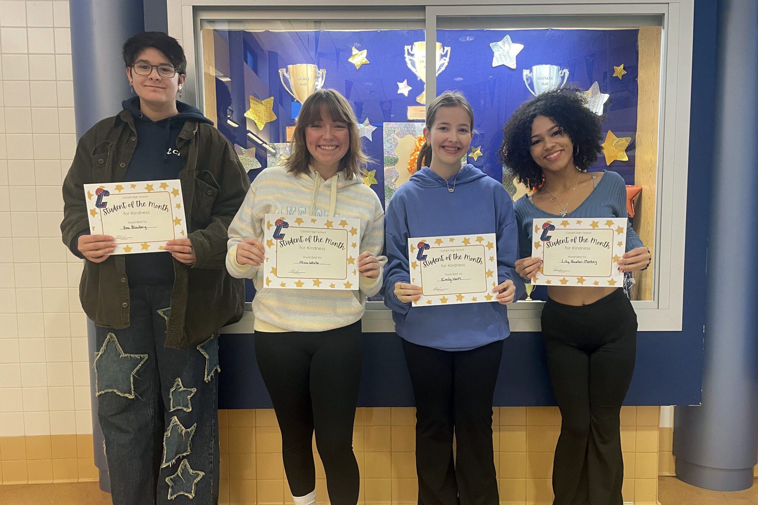 four students holding Student of the Month certificate