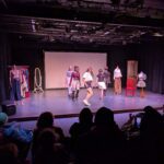 students modeling clothes on runway stage