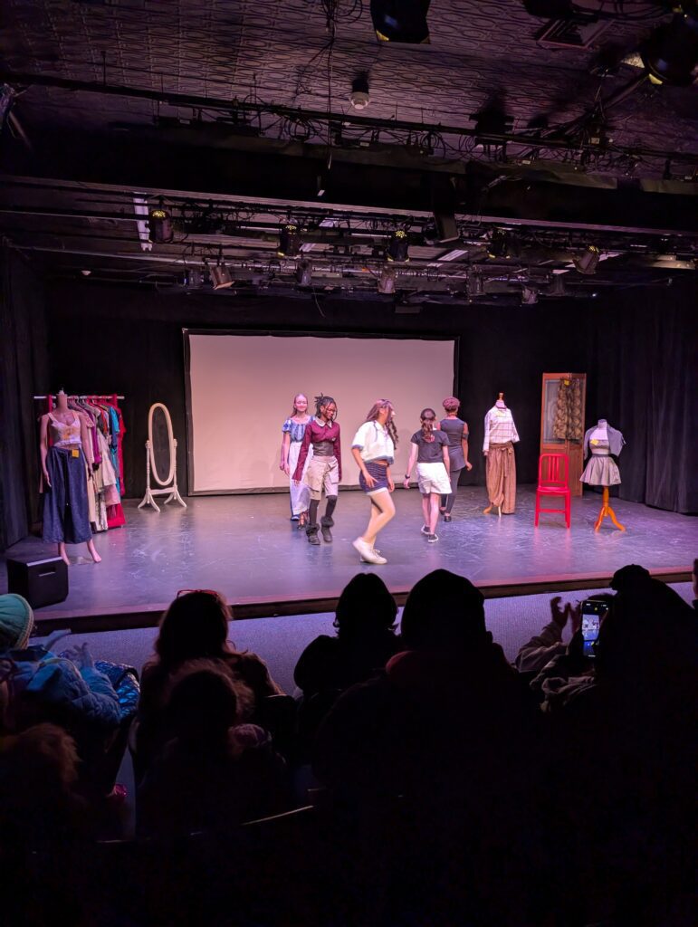 students modeling clothes on runway stage
