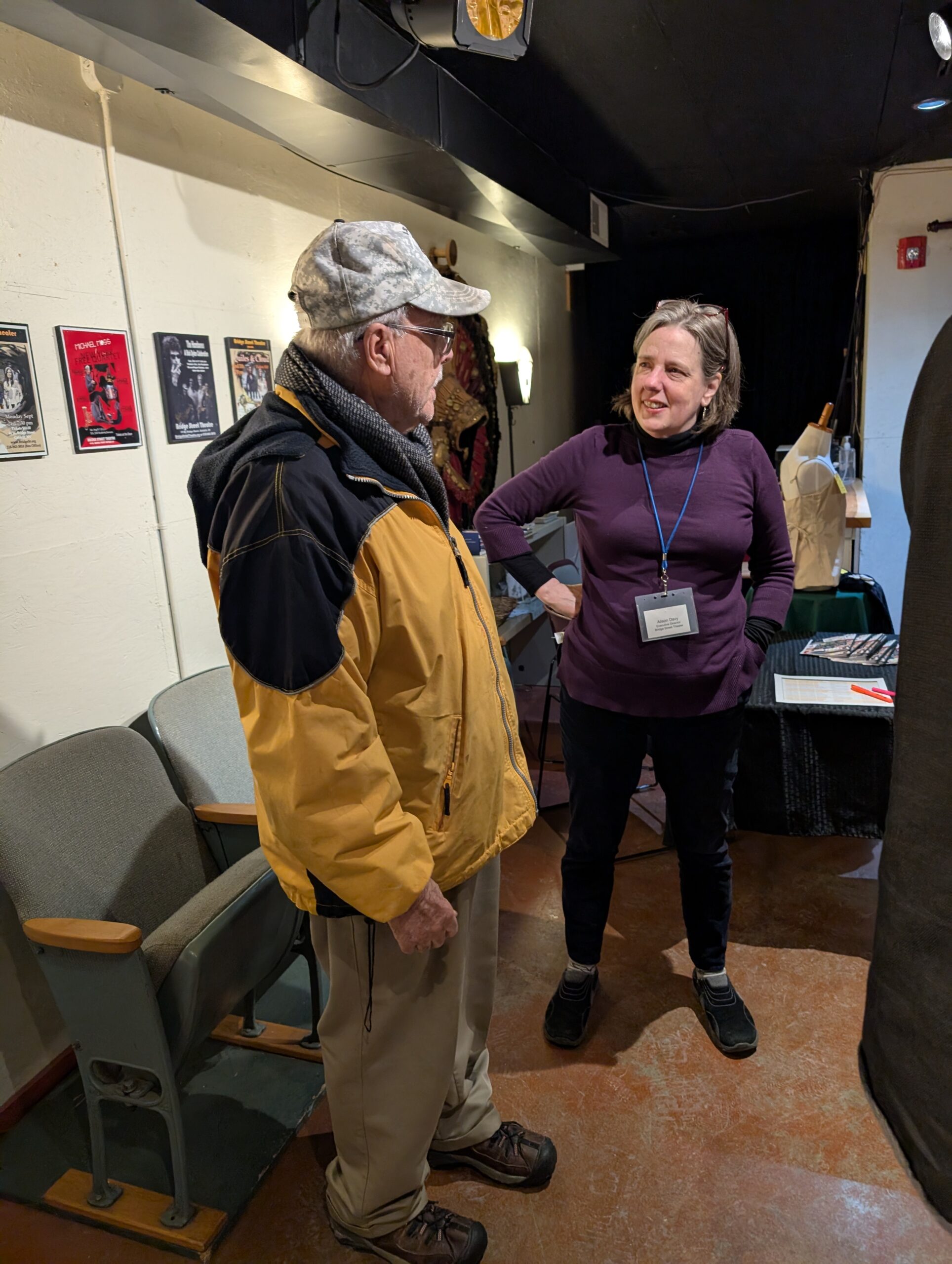 man and woman talking in gallery.