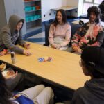 students sitting around table playing cards