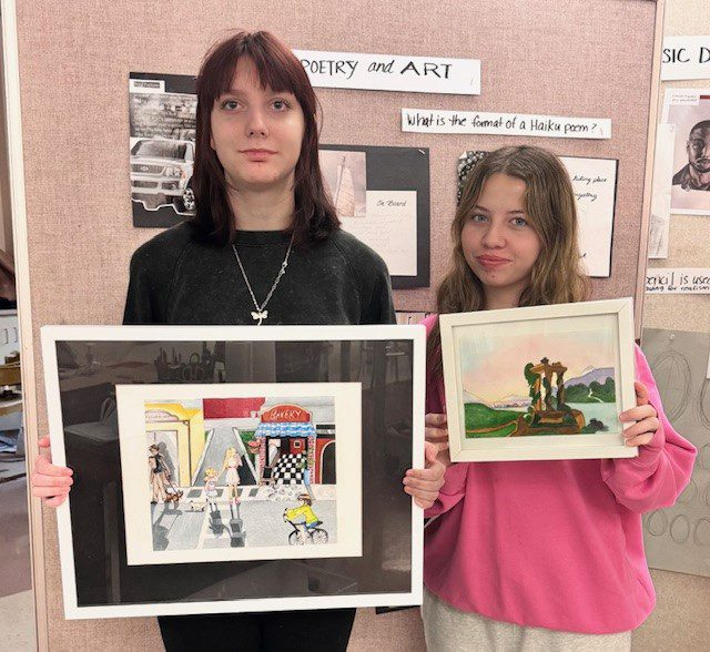 two girls holding artwork