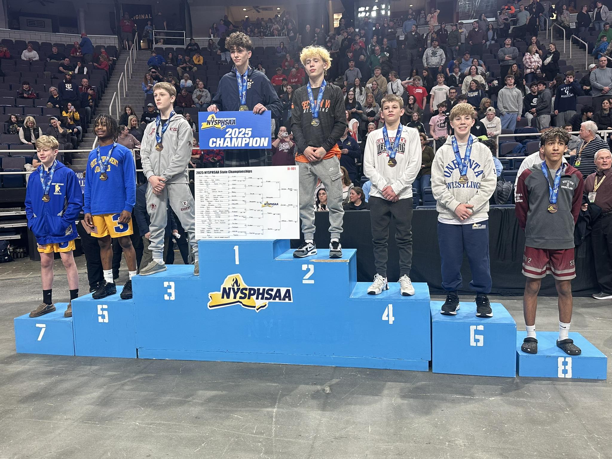 eighth young men wearing medals standing on podium