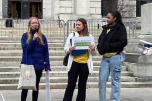 three young women speaking at capitol steps