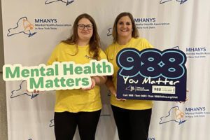 two women pose with mental health matters and 988 You Matter signs