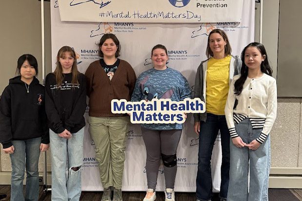 students pose with mental health matters sign