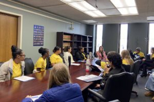 Students seated around table with Michelle Hinchey