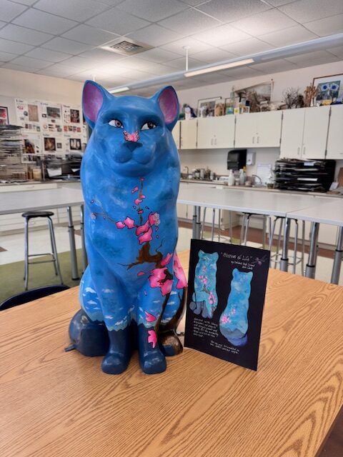 cat with flowers, sky and mountains painted on it