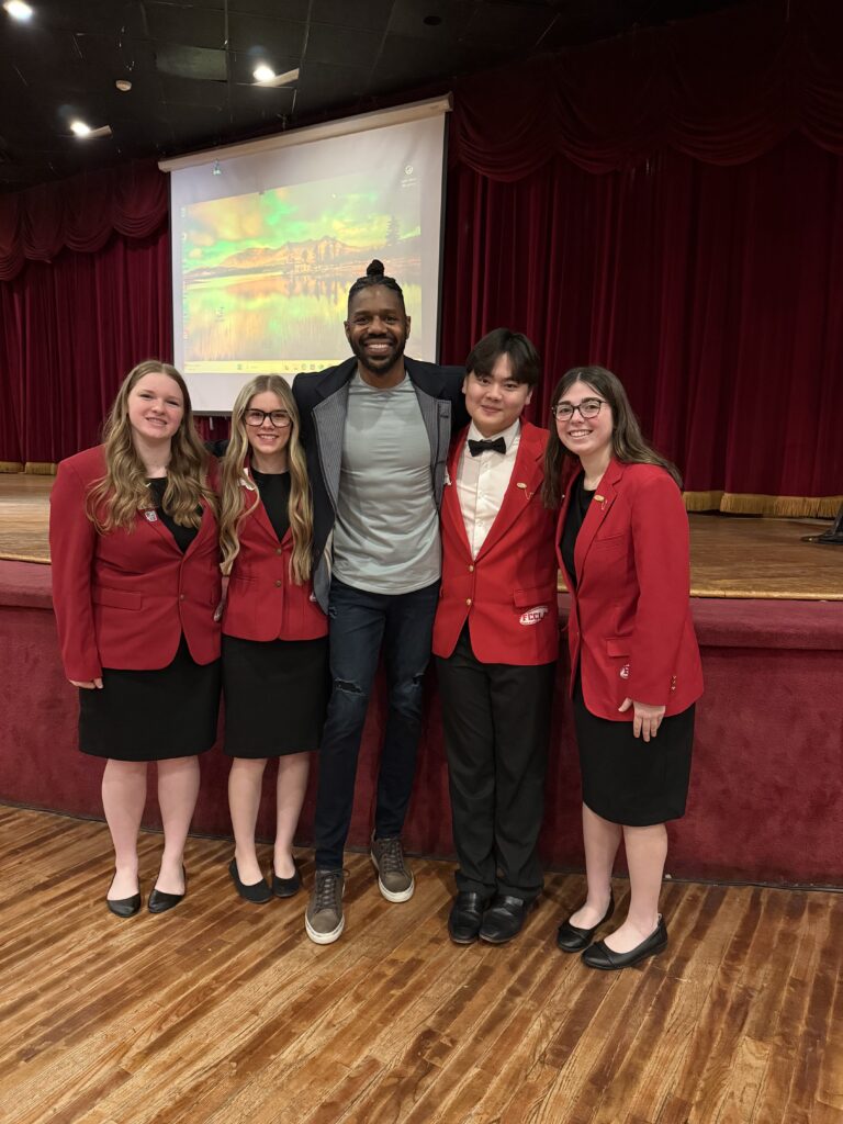 students and man posing for photo