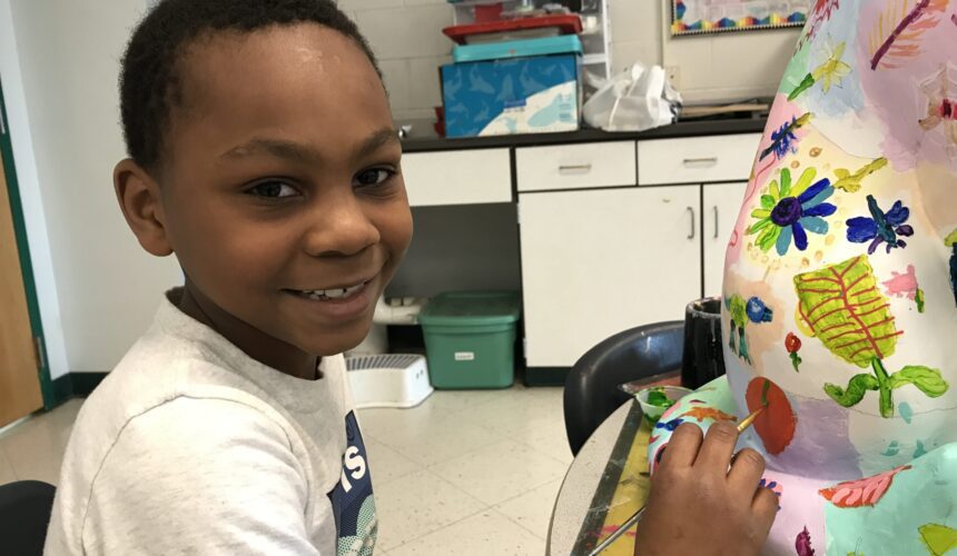 boy painting cat statue