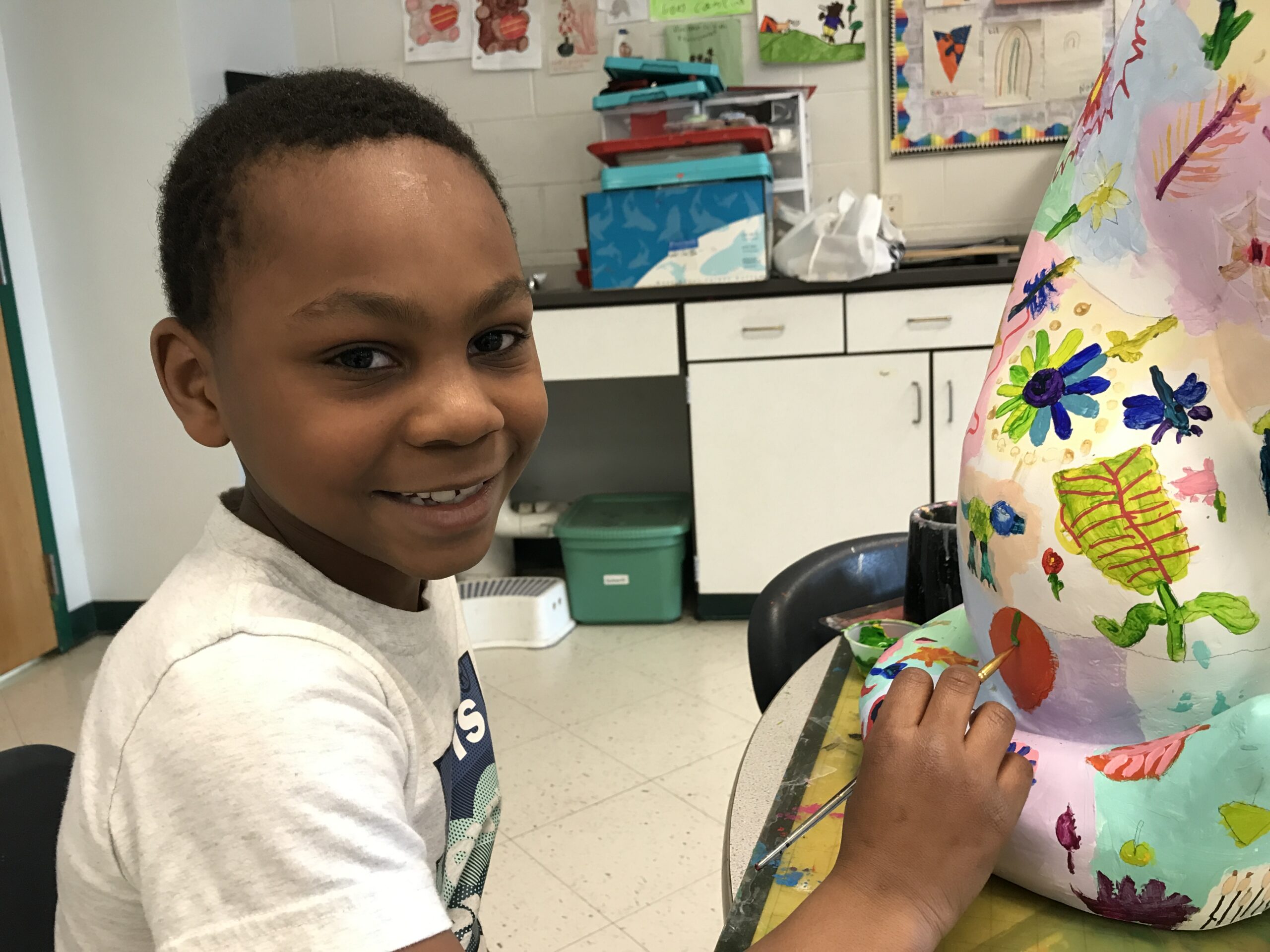 boy painting cat statue