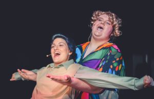 two girls singing on stage