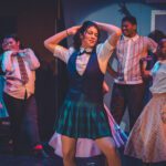 students dancing on stage wear 60s style clothing