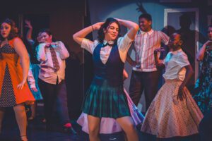 students dancing on stage wear 60s style clothing