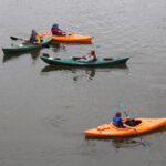 students and teacher in kayaks on river