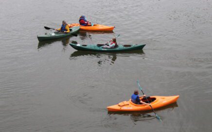 students and teacher in kayaks on river