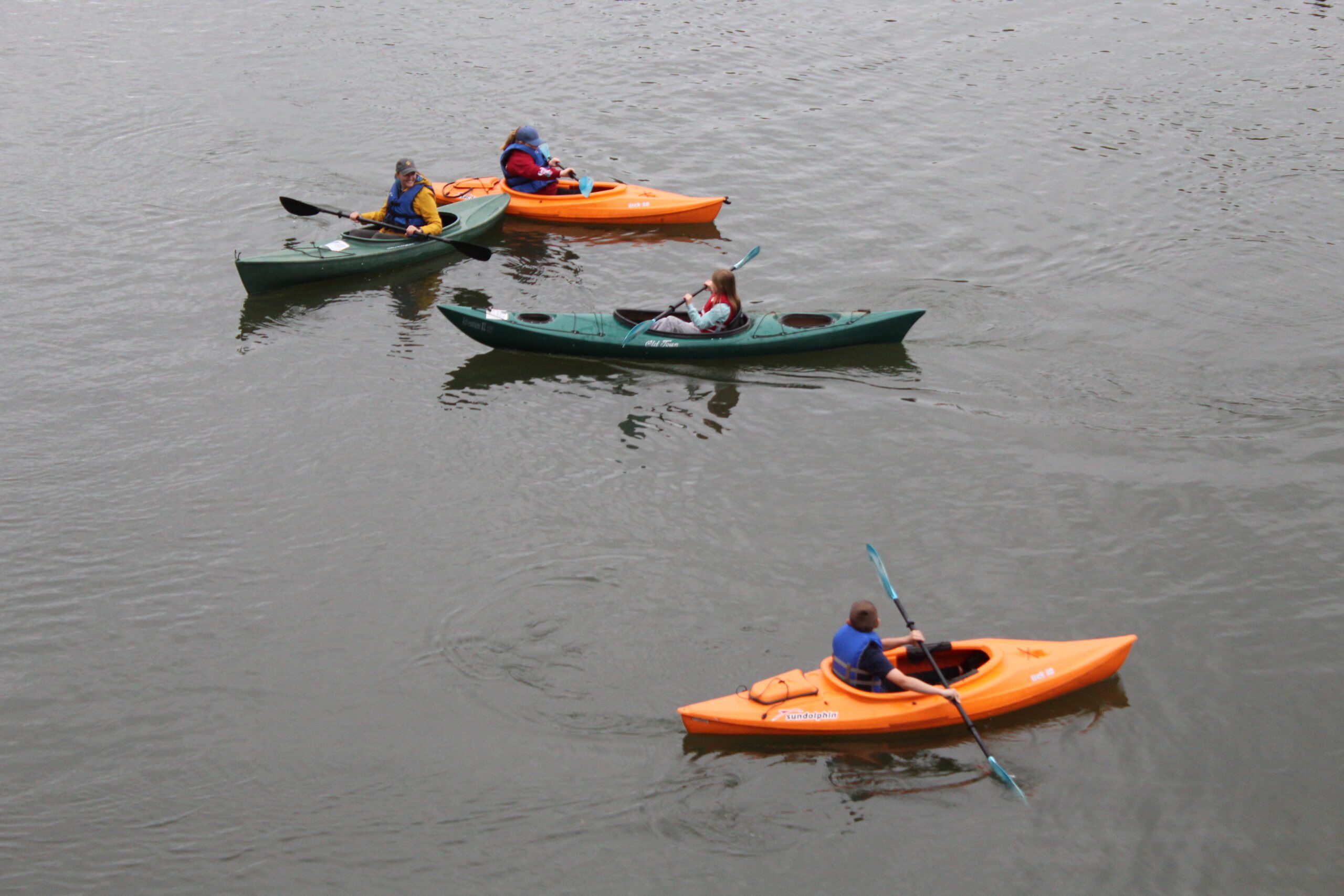 students and teacher in kayaks on river