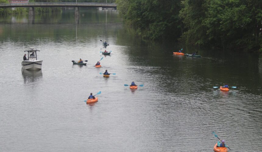 students kayak past sheriff's patrol boat
