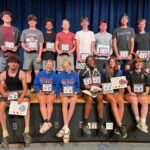 spring sports awardees pose for group photo holding certificates